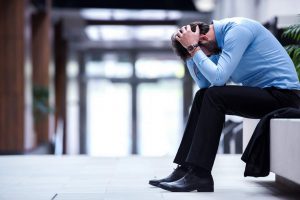 man with head in hands depression