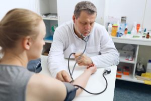 doctor checking patients blood pressure