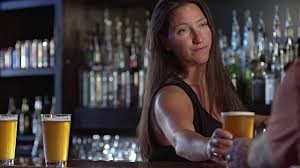 woman bartender serving glass of beer
