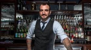 bartender leaning on his bar